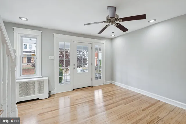a view of an empty room with a window and wooden floor