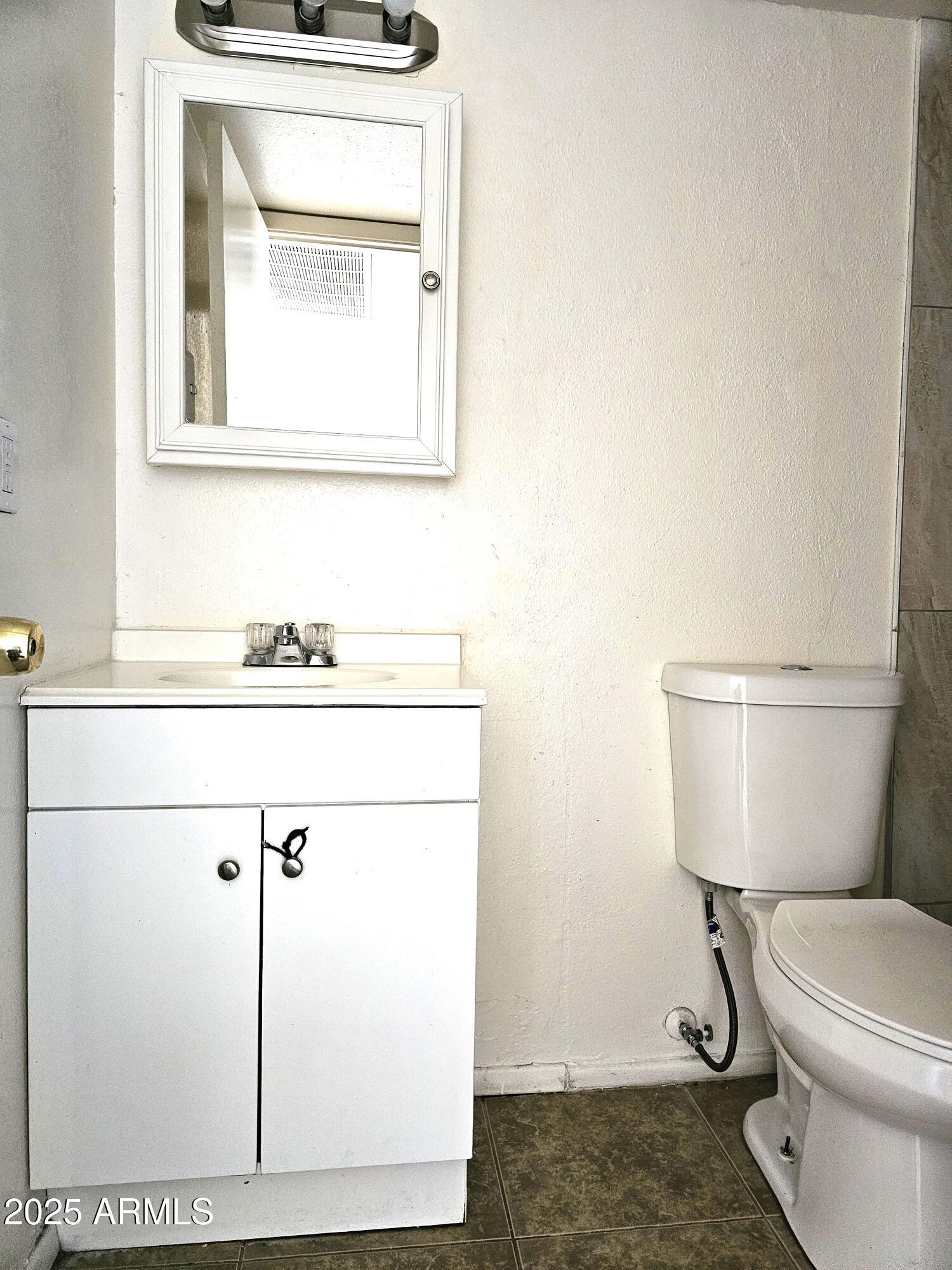 45 North Lyn Rae Drive, Unit 12 Mesa, AZ 85213 - Photo 13 of 24 a bathroom with a toilet a sink and mirror