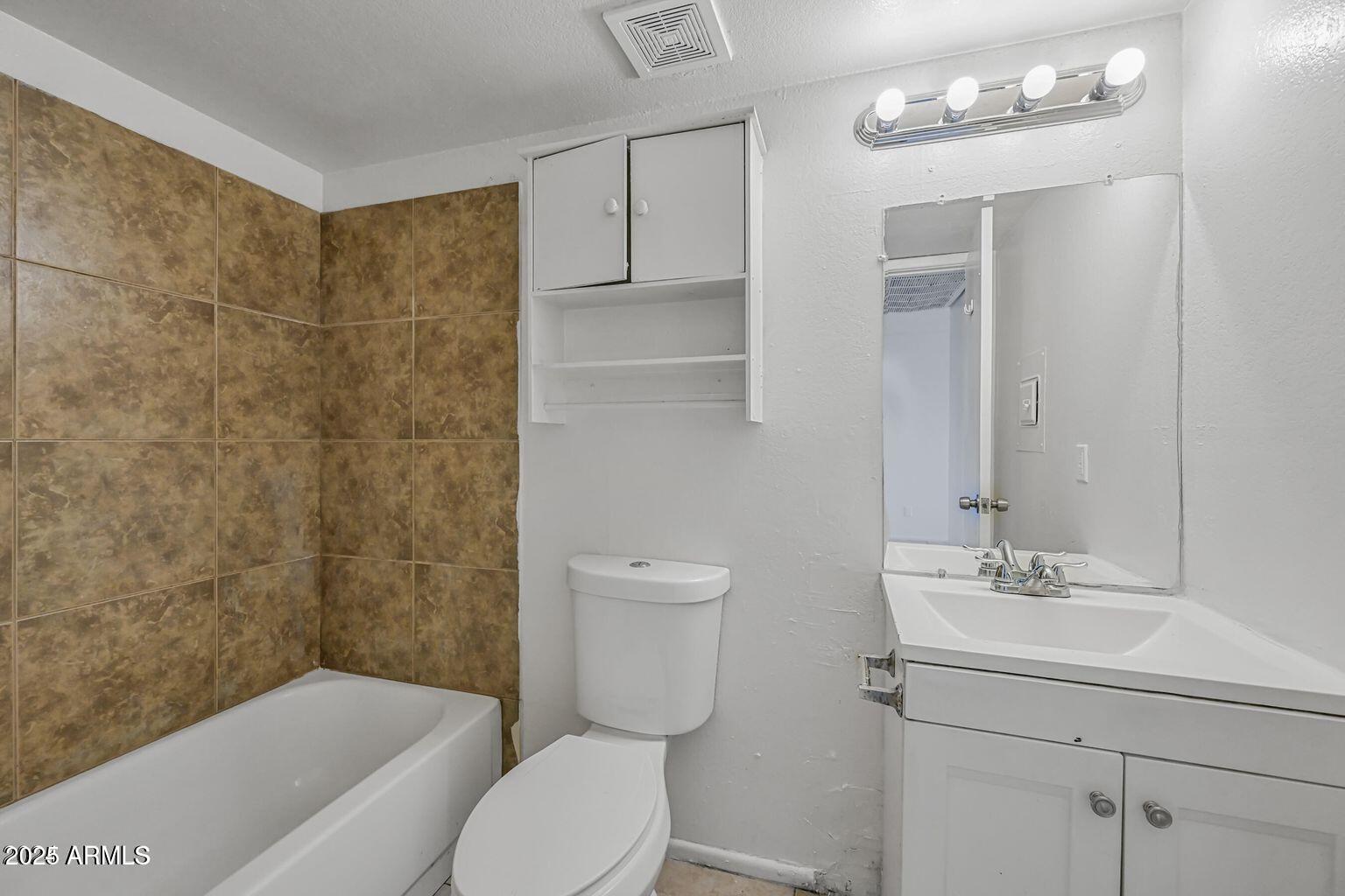 45 North Lyn Rae Drive, Unit 12 Mesa, AZ 85213 - Photo 18 of 24 a bathroom with a toilet a sink a mirror and vanity