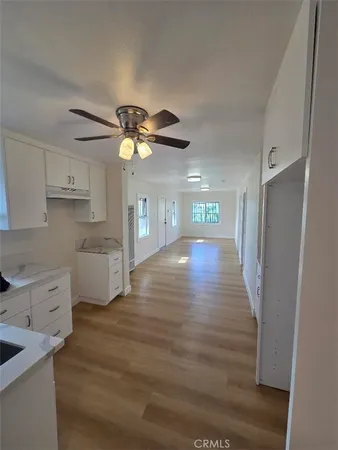 a view of a kitchen with a sink cabinets and wooden floor
