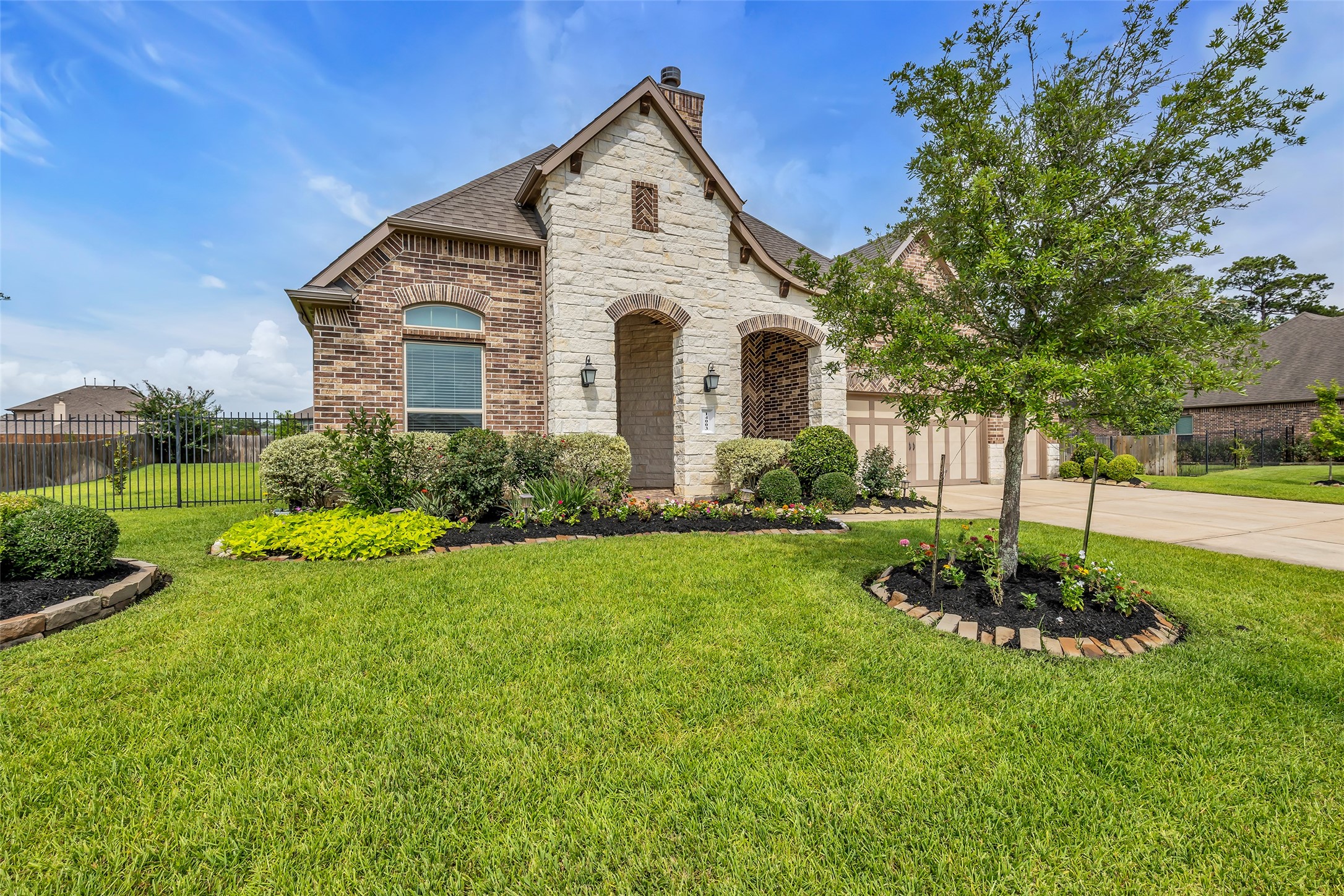 14003 South Evergreen Ridge Court Conroe, TX 77384 - Photo 38 of 43 Beautifully landscaped grounds complement the Texas limestone and brick elevation.