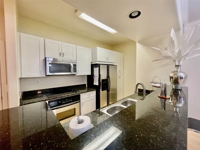 a kitchen with sink refrigerator and stove