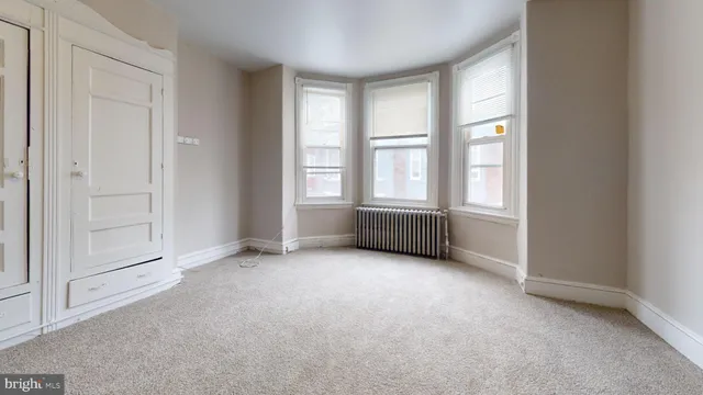 an empty room with windows and closet