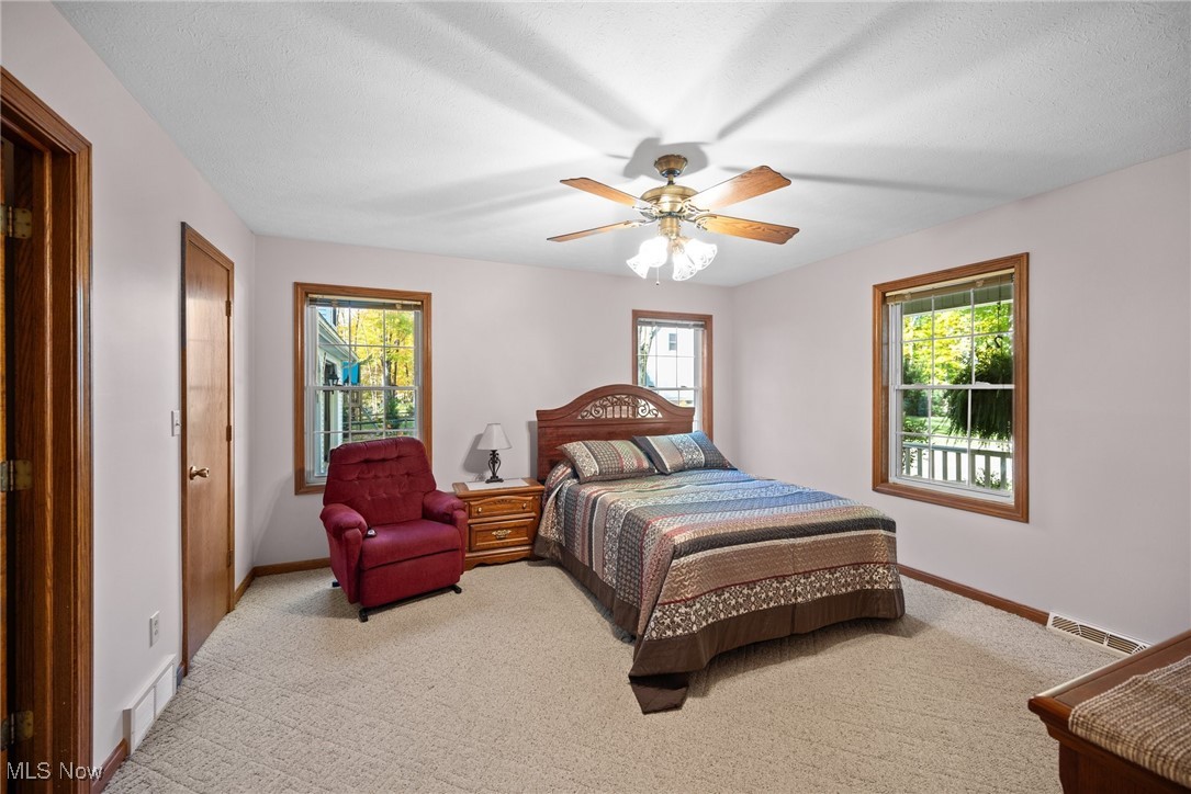 3190 Hamilton Road Medina, OH 44256 - Photo 7 of 37 Carpeted bedroom featuring a textured ceiling, multiple windows, and ceiling fan