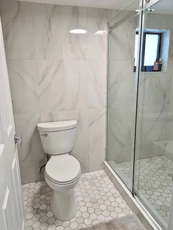 a bathroom with a toilet and a shower