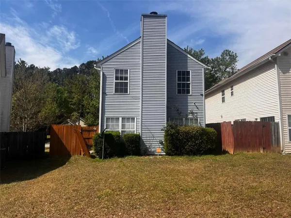 a view of a house with backyard and sitting area