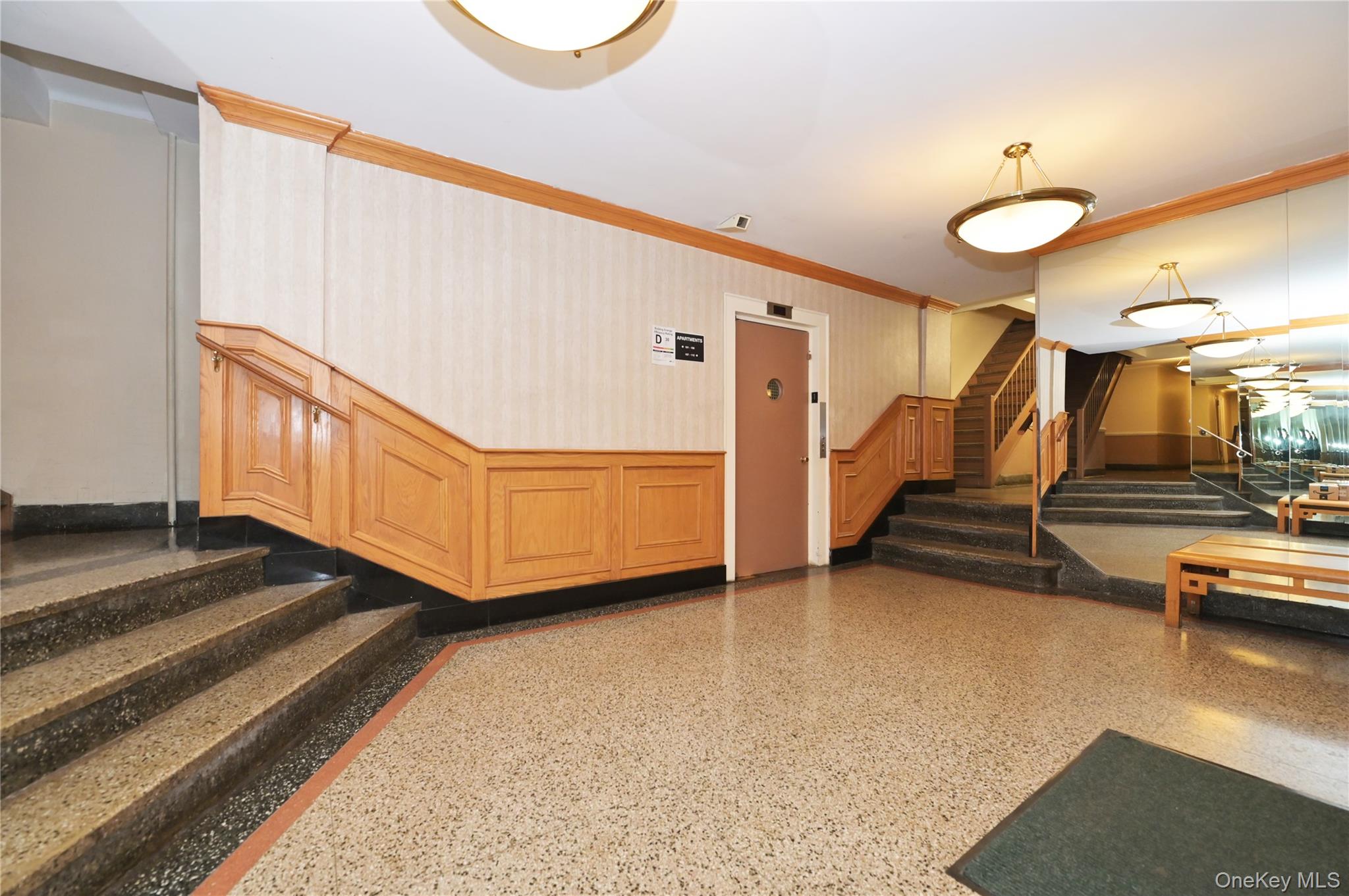 139-09 84th Drive, Unit 306 Queens, NY 11435 - Photo 11 of 12 Common area with stairs, crown molding, wallpapered walls, and wainscoting