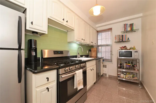 a kitchen with stainless steel appliances a stove a refrigerator and cabinets