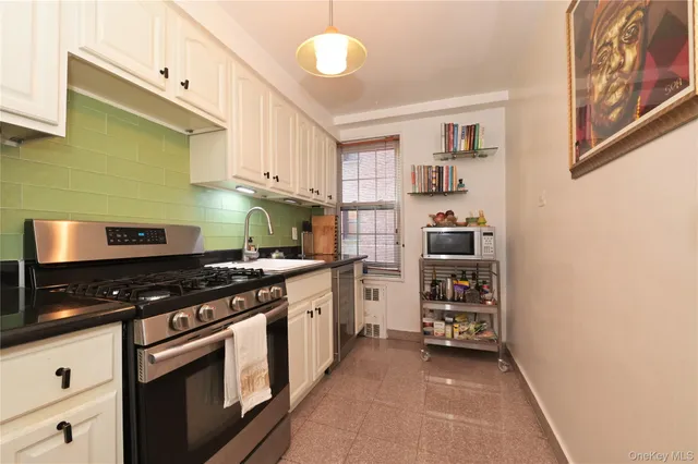 a kitchen with stainless steel appliances granite countertop a stove and cabinets