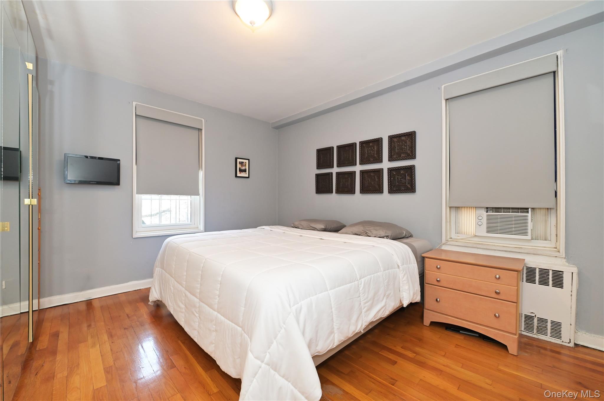 139-09 84th Drive, Unit 306 Queens, NY 11435 - Photo 7 of 12 Bedroom featuring hardwood / wood-style flooring, radiator, and cooling unit