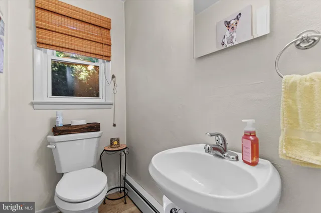 a bathroom with a toilet a sink and mirror