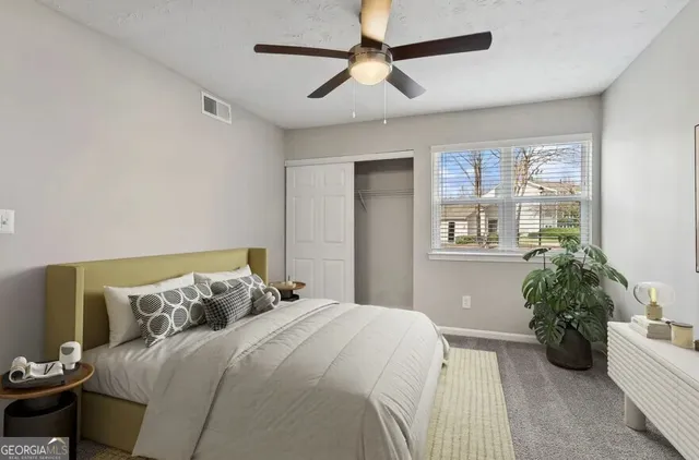 a bedroom with a bed and a potted plant