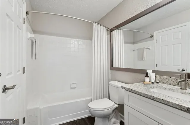 a bathroom with a granite countertop sink toilet and shower