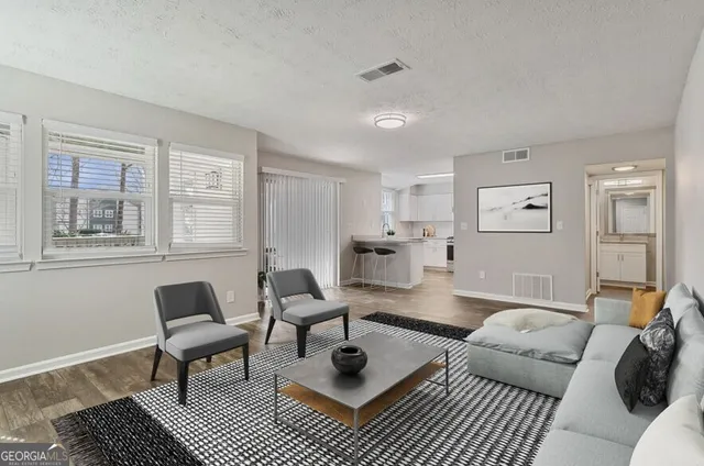 a living room with furniture a rug and wall painting