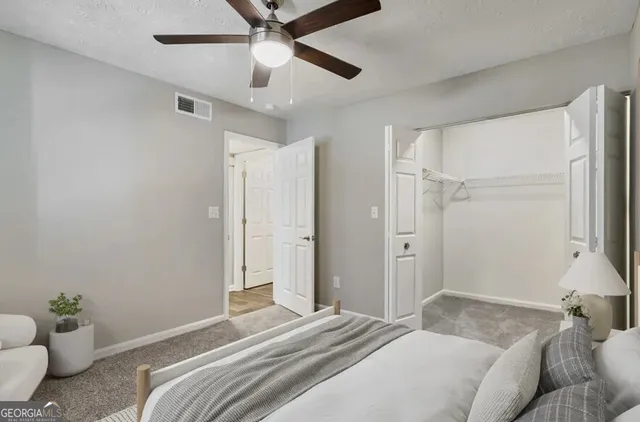a bedroom with a bed and a chandelier fan