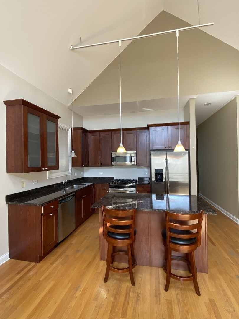 Undisclosed Address Chicago, IL 60613 - Photo 4 of 10 a kitchen with stainless steel appliances granite countertop a stove a sink and a refrigerator