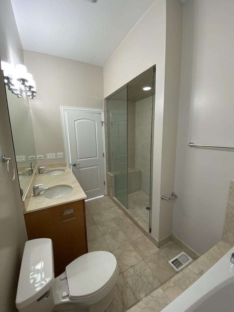 Undisclosed Address Chicago, IL 60613 - Photo 8 of 10 a bathroom with a sink a toilet and shower