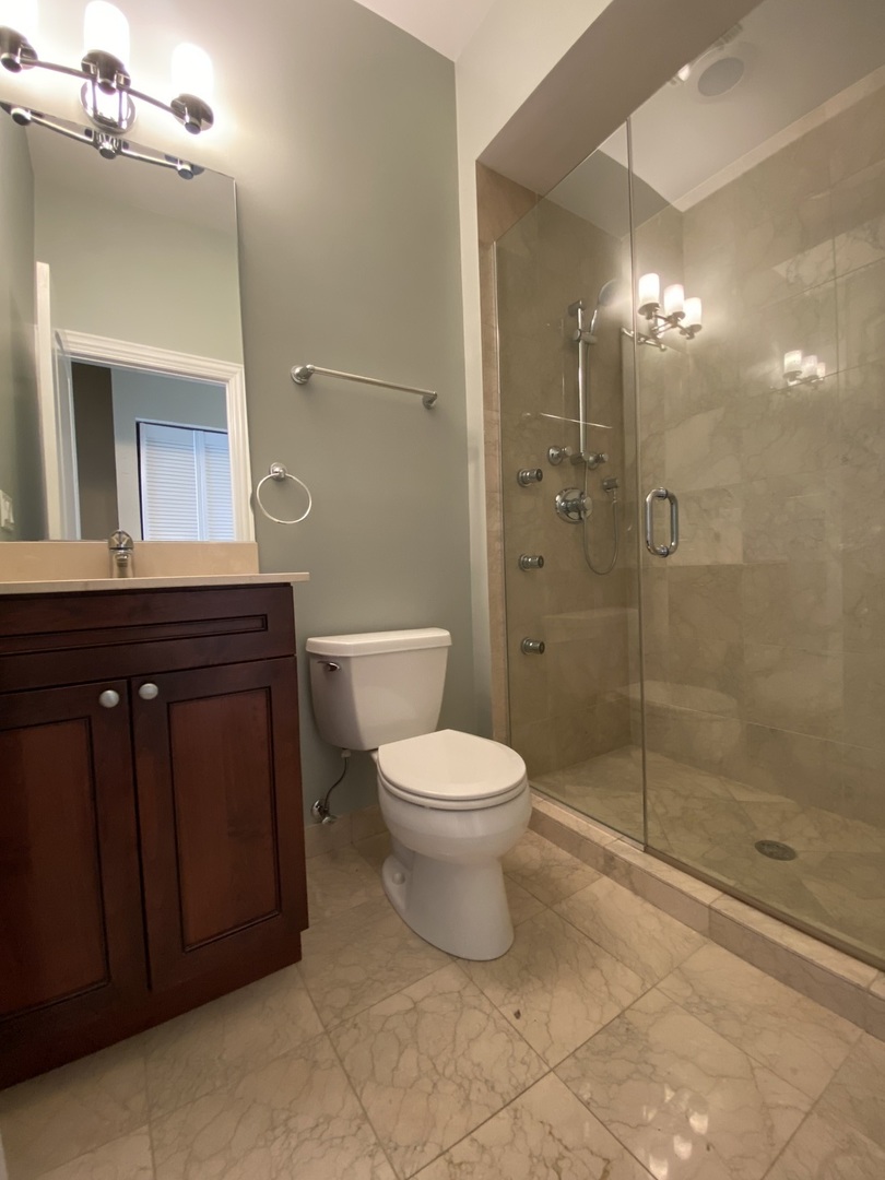 Undisclosed Address Chicago, IL 60613 - Photo 9 of 10 a bathroom with a toilet a sink and shower