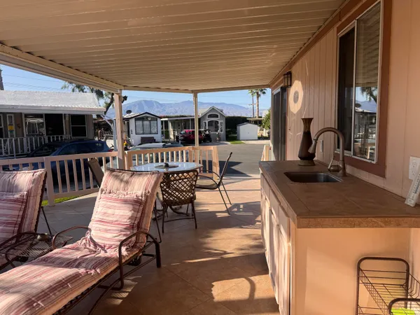 a view of a patio with table and chairs a barbeque with wooden floor and fence