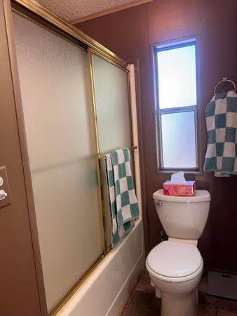 a bathroom with a toilet and a shower