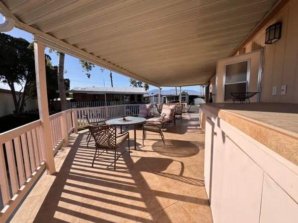 a view of a patio with table and chairs with wooden floor and fence