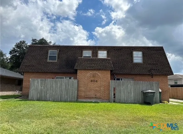 a backyard of a house with barbeque oven and garage