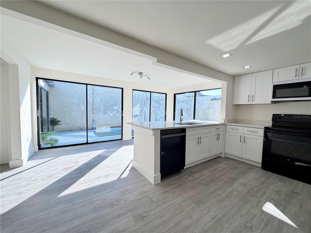 7314 Patio Row Hudson, FL 34667 - Photo 4 of 17 a large kitchen with stainless steel appliances granite countertop a stove a sink and a white cabinets