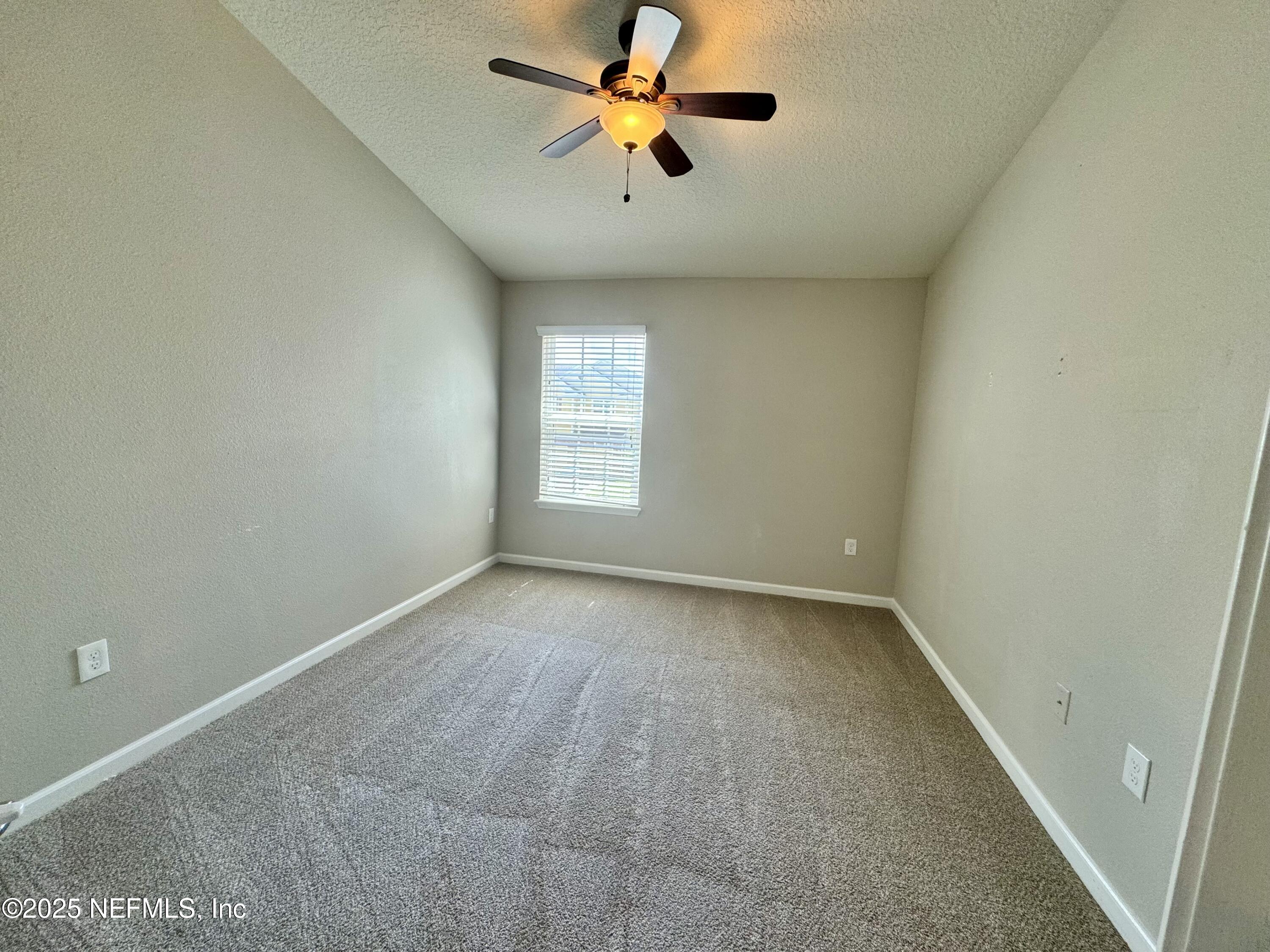 6839 Roundleaf Drive Jacksonville, FL 32258 - Photo 20 of 30 an empty room with windows and a ceiling fan