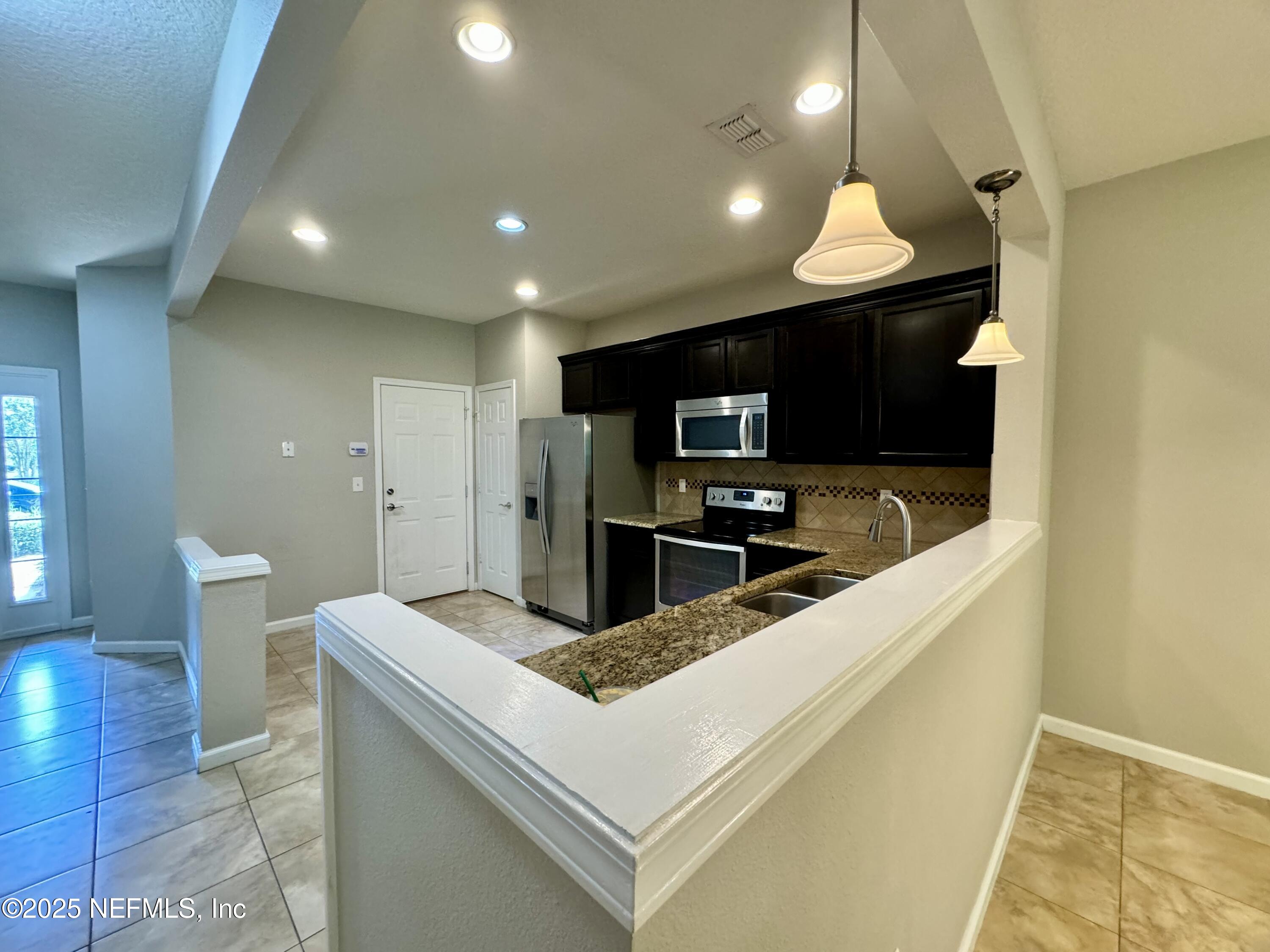 6839 Roundleaf Drive Jacksonville, FL 32258 - Photo 4 of 30 a kitchen with kitchen island a sink stainless steel appliances and cabinets