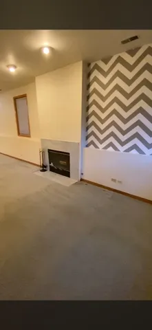 a view of a livingroom with an empty space and a kitchen