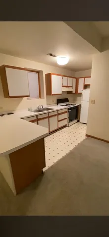 a kitchen with stainless steel appliances kitchen island sink refrigerator and stove