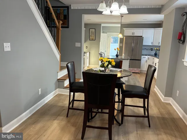 a dining room with furniture a chandelier and wooden floor