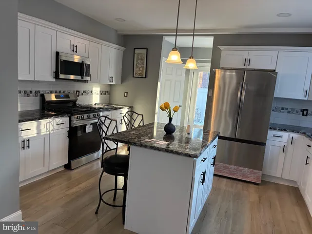 a kitchen with stainless steel appliances a stove refrigerator a microwave a sink and a refrigerator