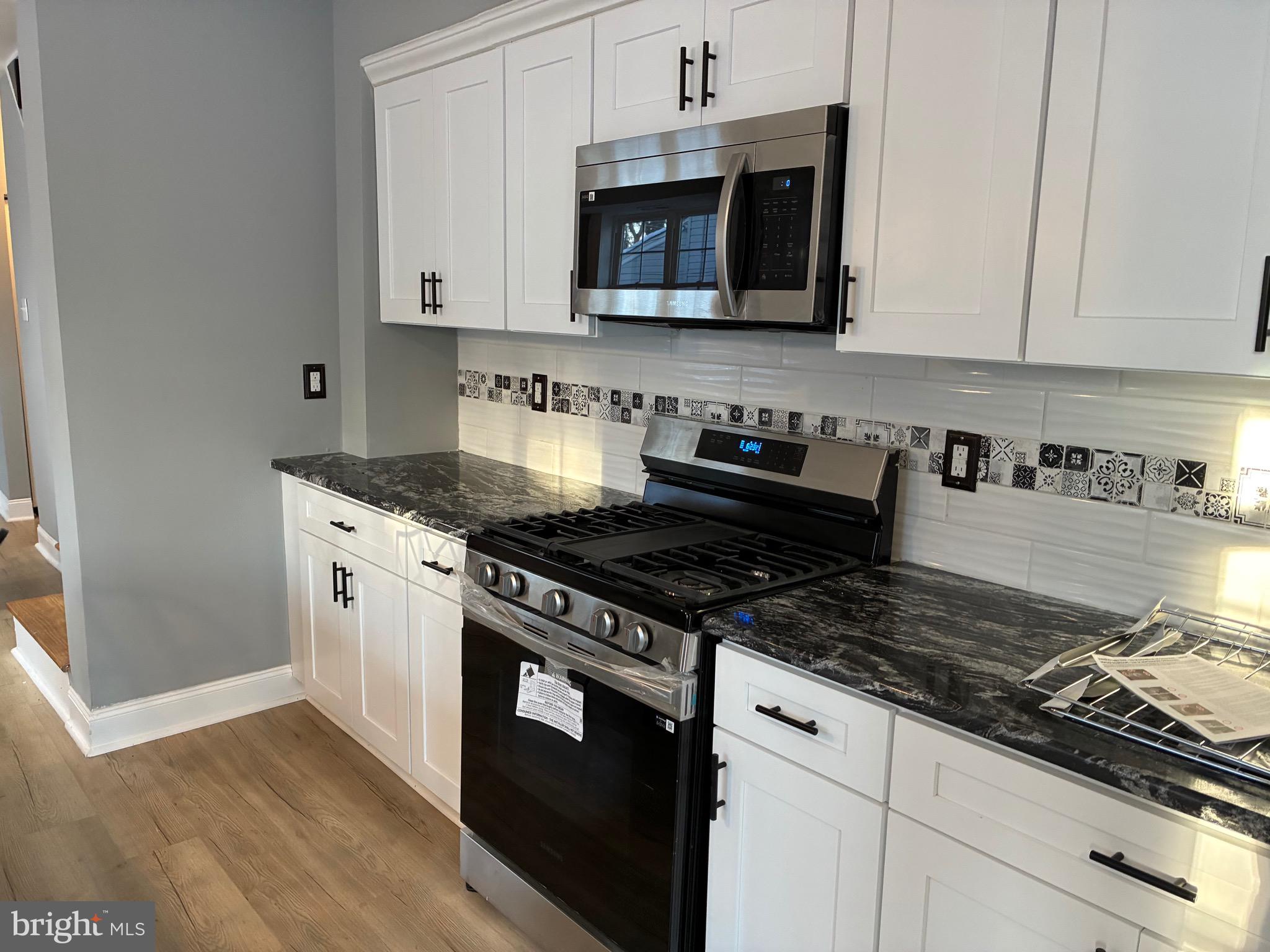 80 East 3rd Street Moorestown, NJ 08057 - Photo 8 of 37 a kitchen with stainless steel appliances granite countertop white cabinets stove top oven and granite counter