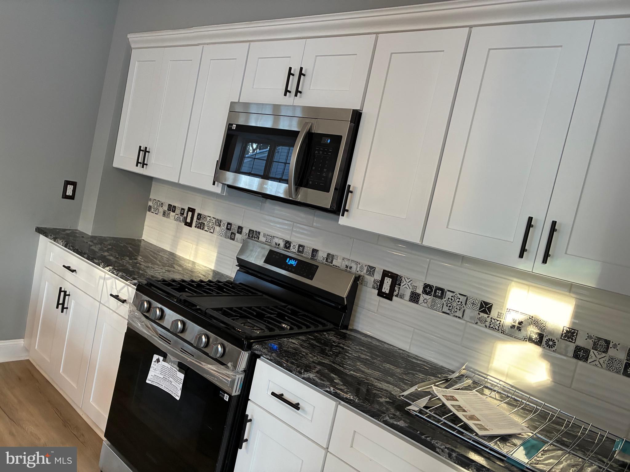 80 East 3rd Street Moorestown, NJ 08057 - Photo 10 of 37 a kitchen with granite countertop a stove and a microwave