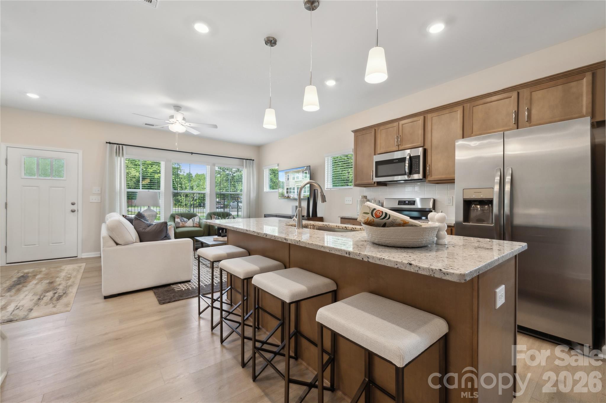 5853 Tuckaseegee Road, Unit 5 Charlotte, NC 28208 - Photo 6 of 24 a kitchen with kitchen island a large counter top space a sink stainless steel appliances and cabinets