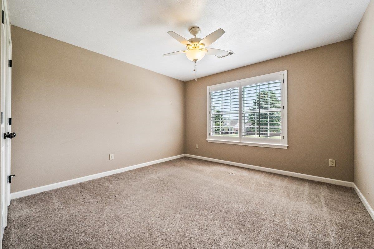 583 Rosemark Road Atoka, TN 38004 - Photo 20 of 25 an empty room with windows and chandelier fan