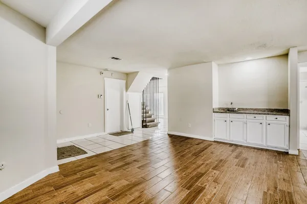 a view of an empty room with wooden floor