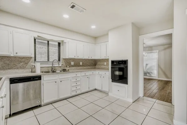 a kitchen with granite countertop white cabinets and white appliances