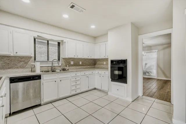 a kitchen with granite countertop white cabinets and white appliances