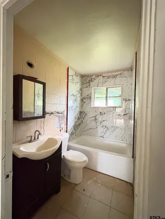 a view of an empty room with wooden floor and window
