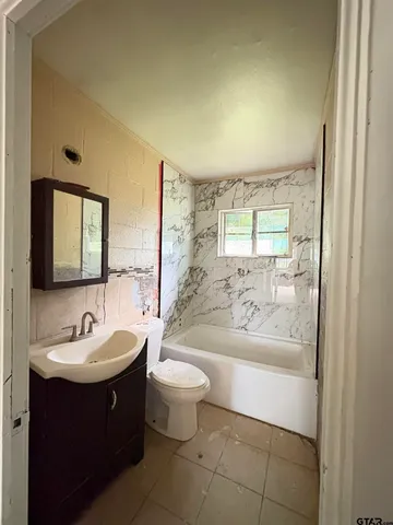 a view of an empty room with wooden floor and window
