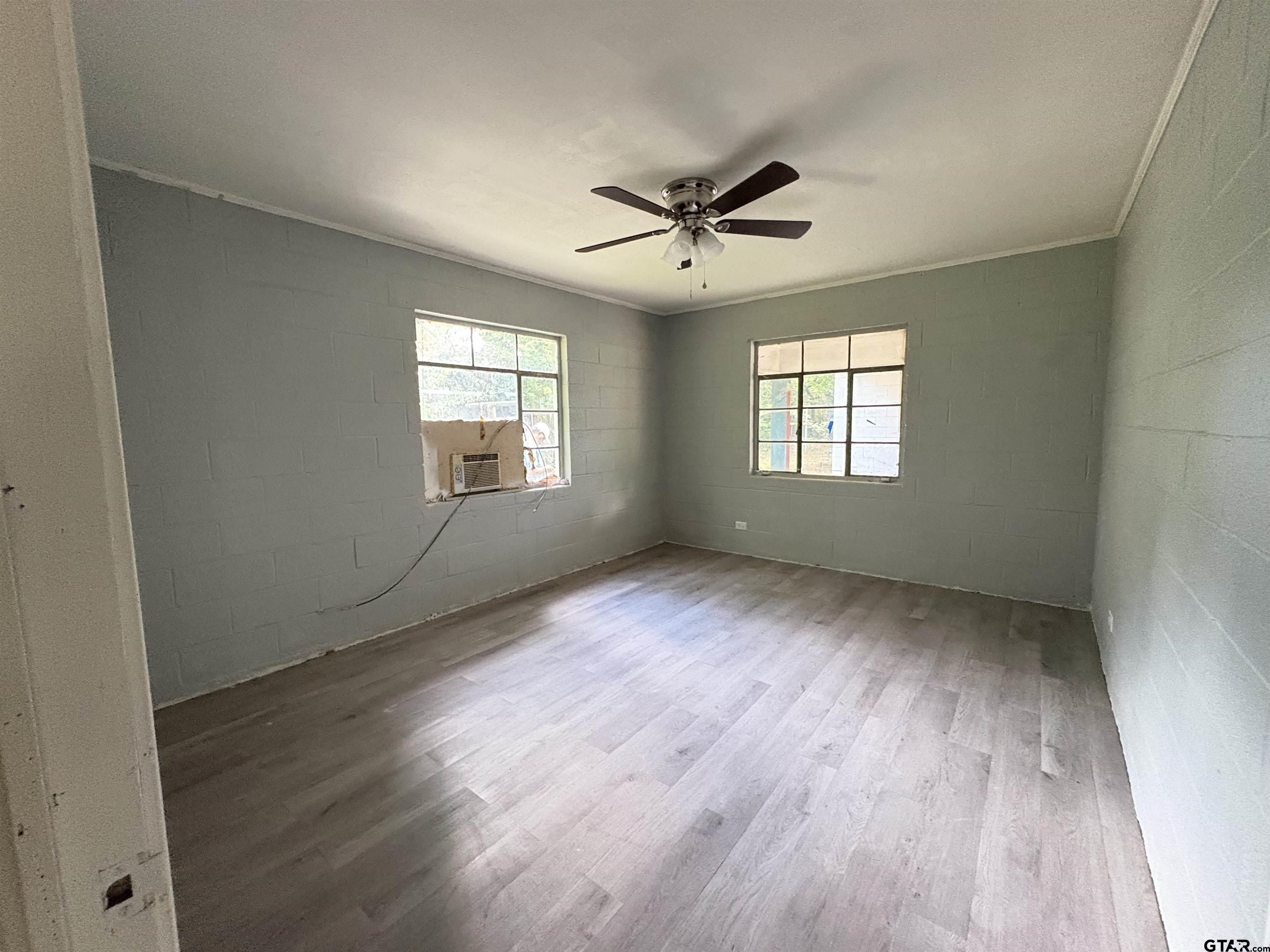 110 East 9th Street Mount Pleasant, TX 75455 - Photo 12 of 27 a view of an empty room with wooden floor and window