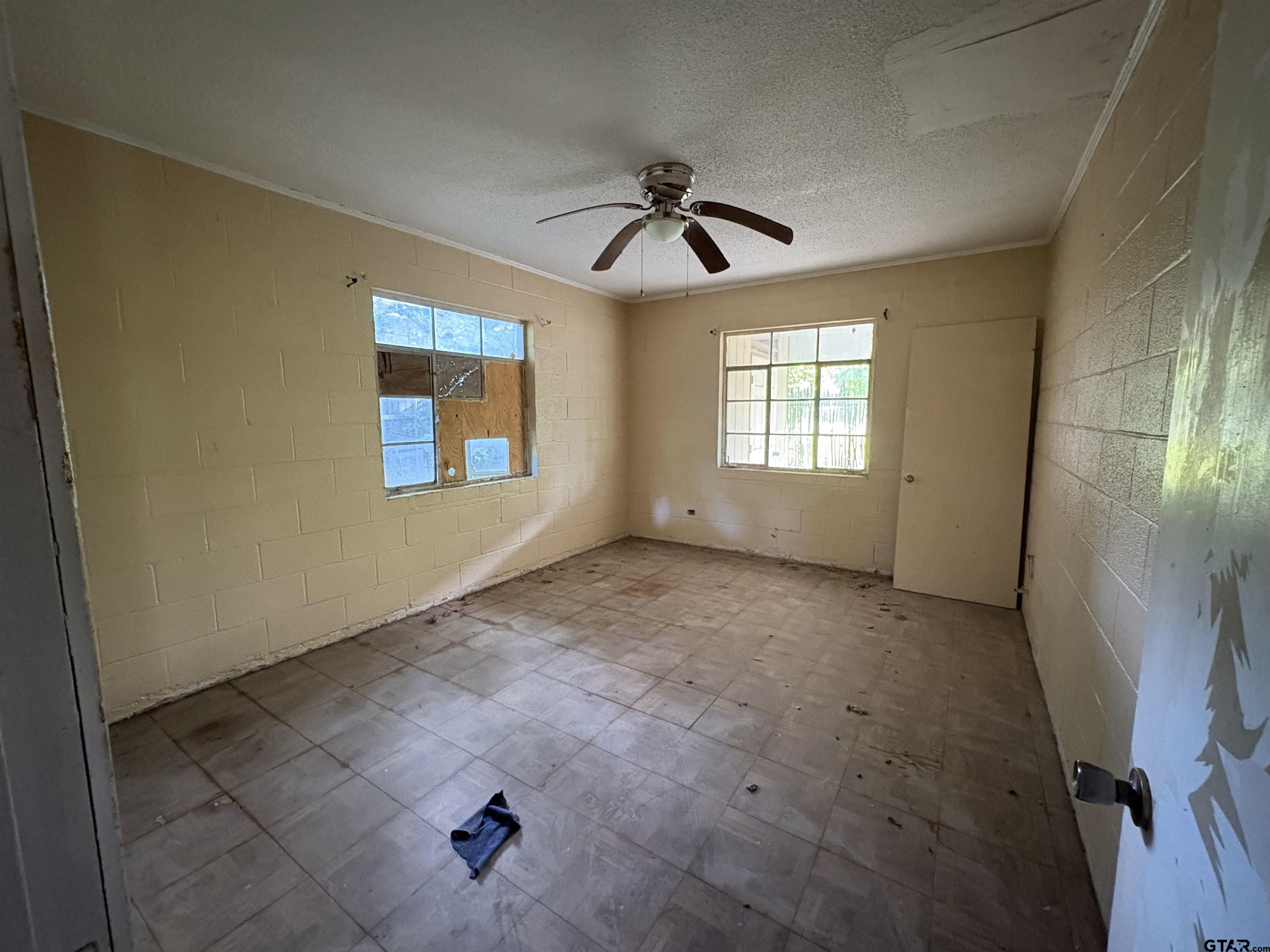 110 East 9th Street Mount Pleasant, TX 75455 - Photo 19 of 27 an empty room with windows and fan