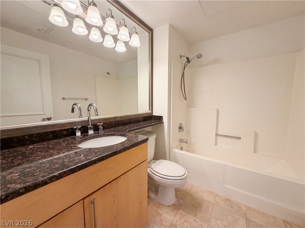 230 East Flamingo Road, Unit 320 Las Vegas, NV 89169 - Photo 12 of 19 A refined bathroom features a single vanity with stone counters and an integrated sink, complementing the tiled flooring and tub/shower combination.