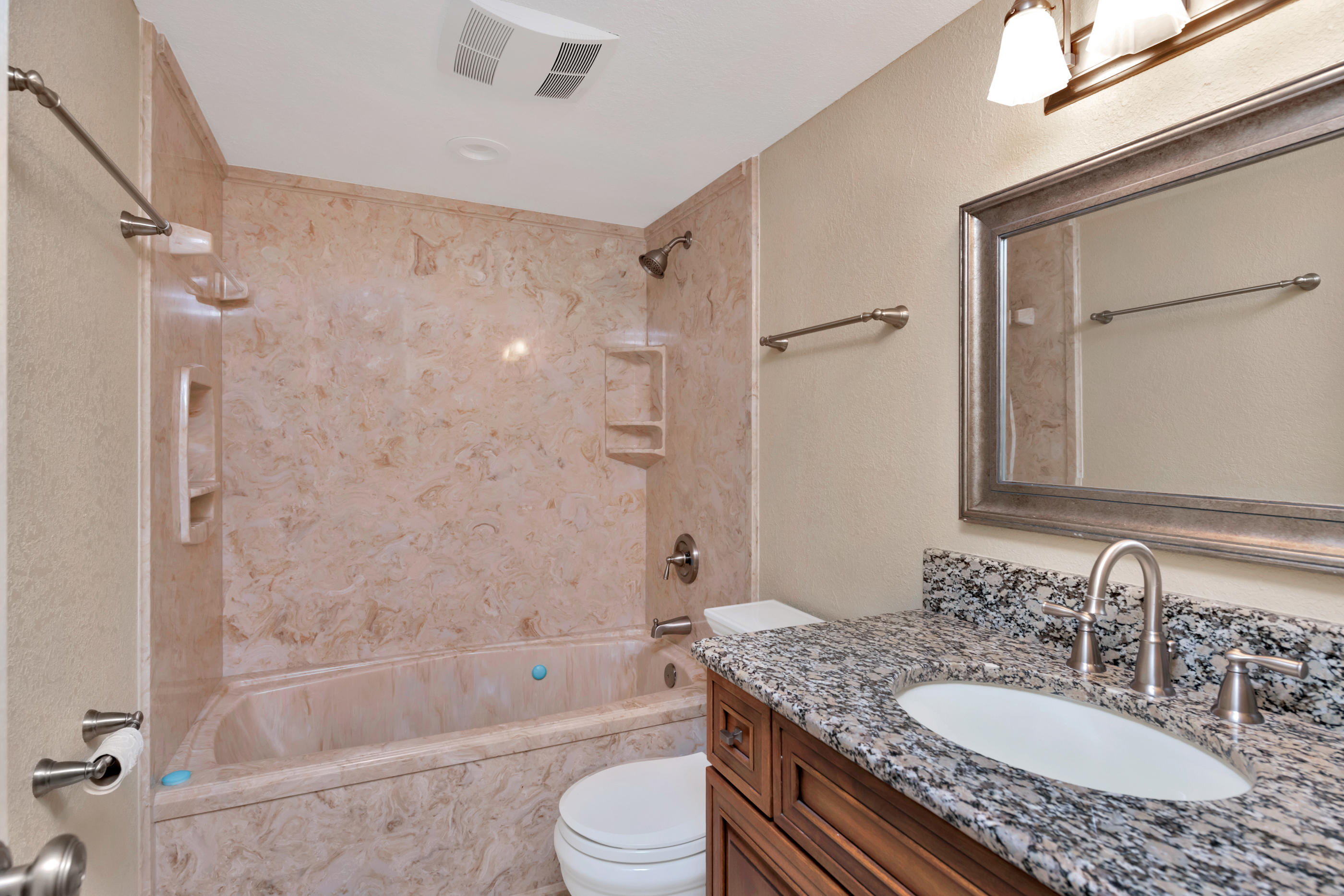 151 Calhoun Avenue, Unit 409 Destin, FL 32541 - Photo 12 of 15 a bathroom with a granite countertop sink toilet mirror and shower