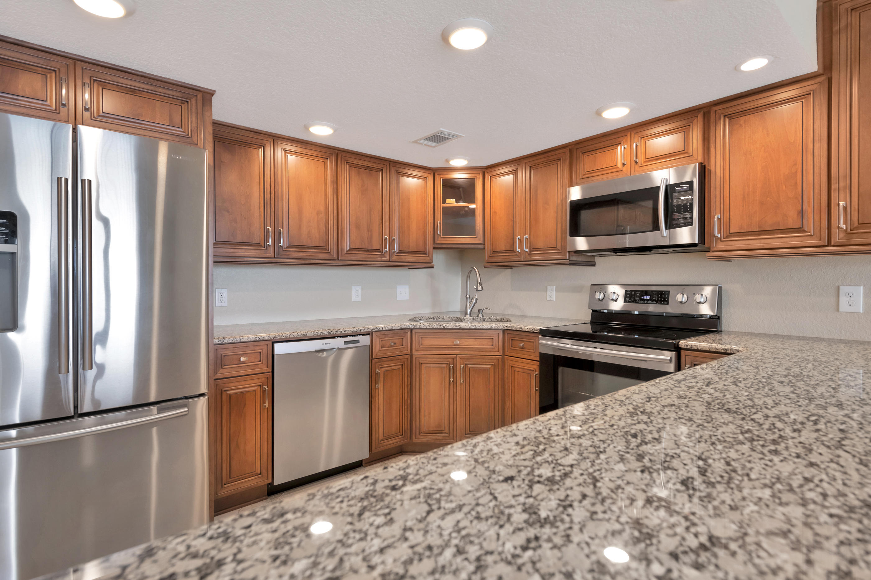 151 Calhoun Avenue, Unit 409 Destin, FL 32541 - Photo 3 of 15 a kitchen with stainless steel appliances granite countertop a refrigerator stove top oven a sink and dishwasher