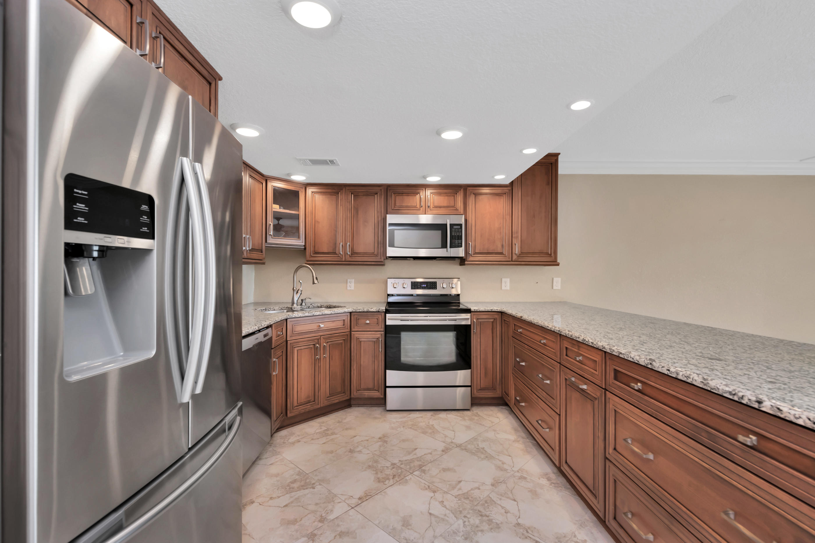 151 Calhoun Avenue, Unit 409 Destin, FL 32541 - Photo 4 of 15 a large kitchen with stainless steel appliances granite countertop a refrigerator and a sink