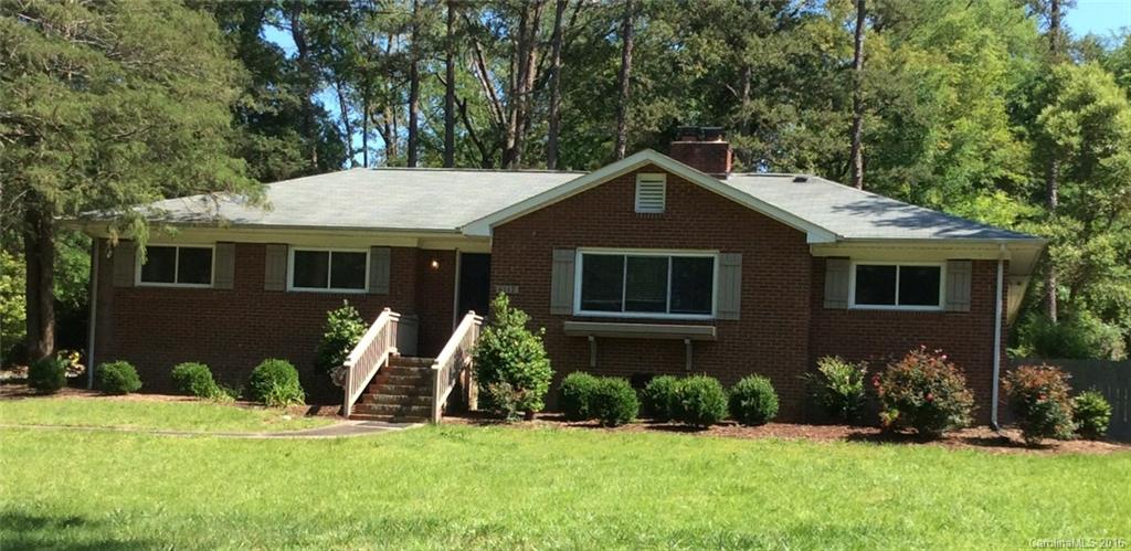 a front view of a house with a yard and trees