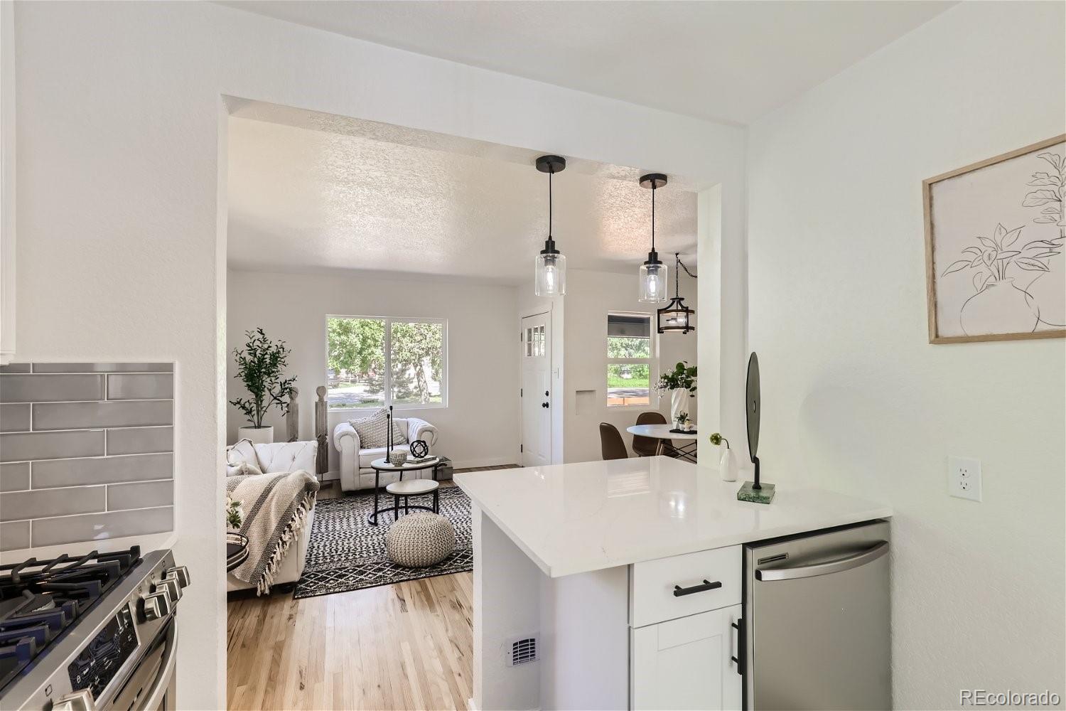 3090 Pierce Street Wheat Ridge, CO 80214 - Photo 11 of 28 a kitchen with granite countertop a sink stove and cabinets